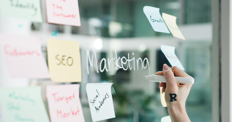 sticky notes with various marketing strategies on glass